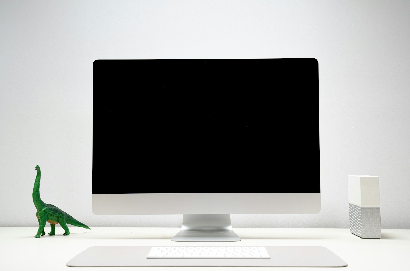 Desktop computer display and accessories on a desk.