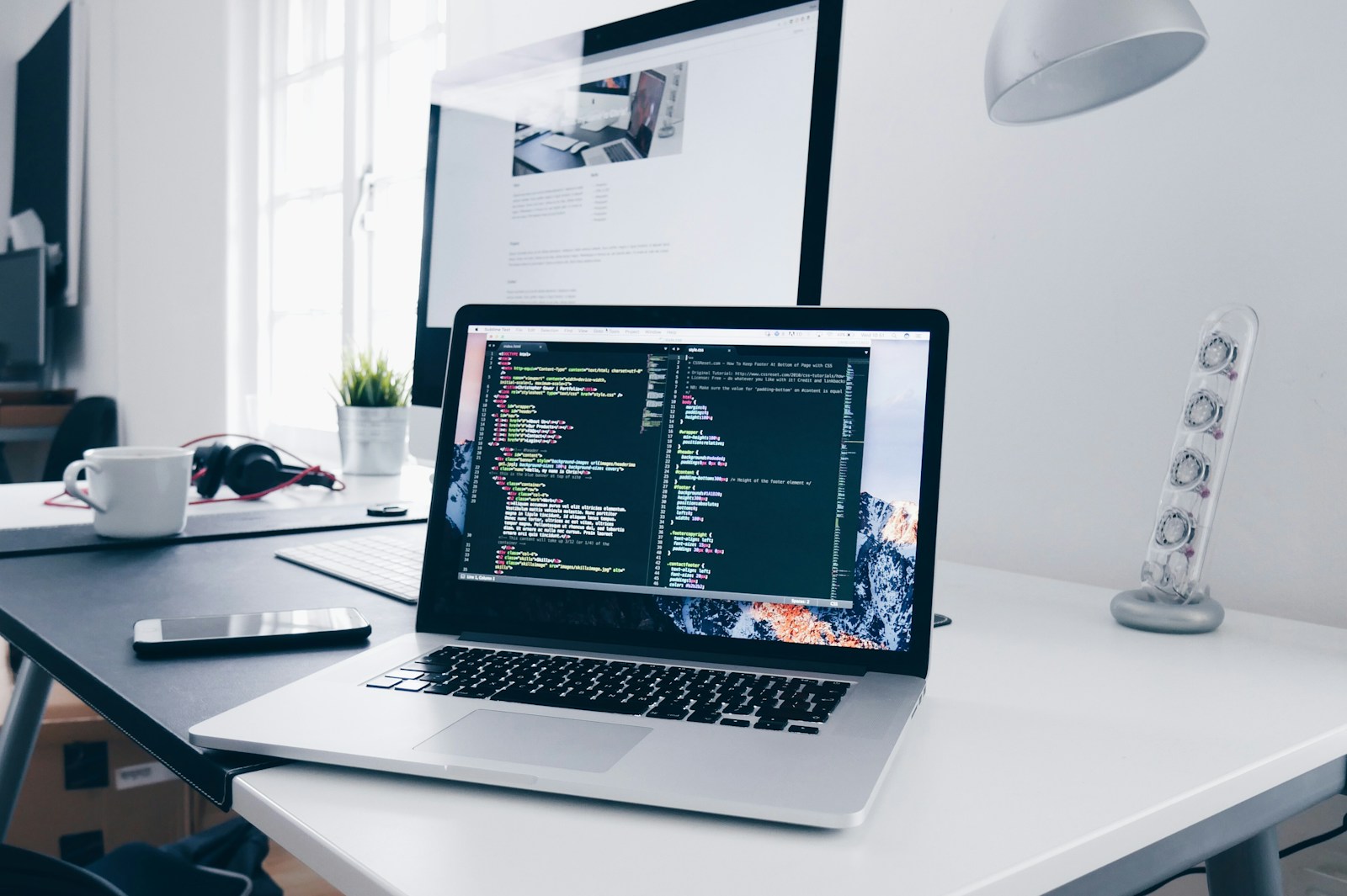Laptop displaying code on a software development workspace.