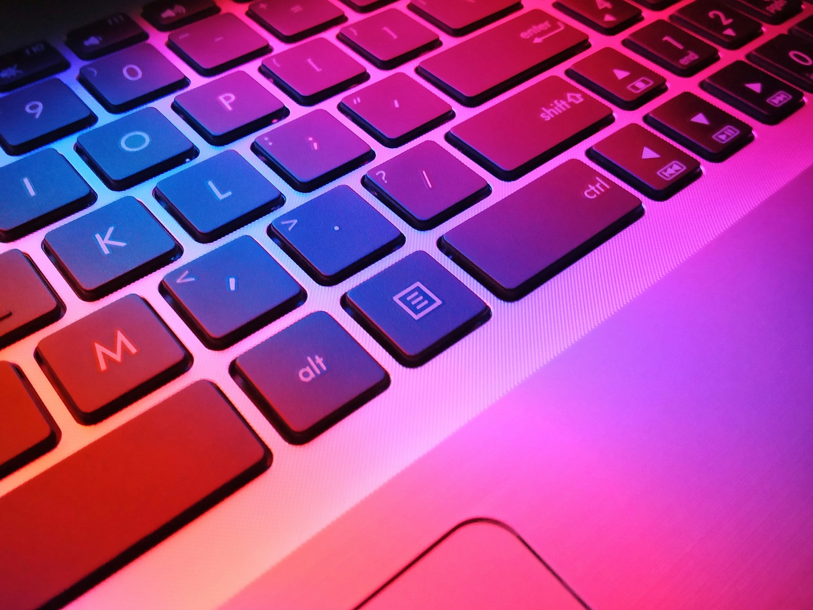Close-up of a computer keyboard with red and blue lighting.