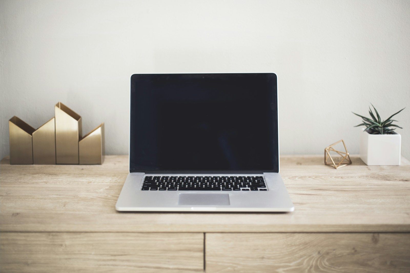 Open laptop on a wooden desk, illustrating connected personal services.