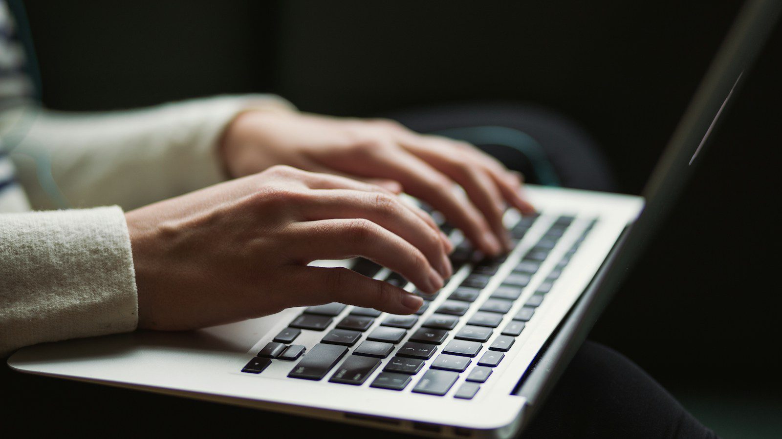 A professional working at a laptop, representing oversight of autonomous AI agents.